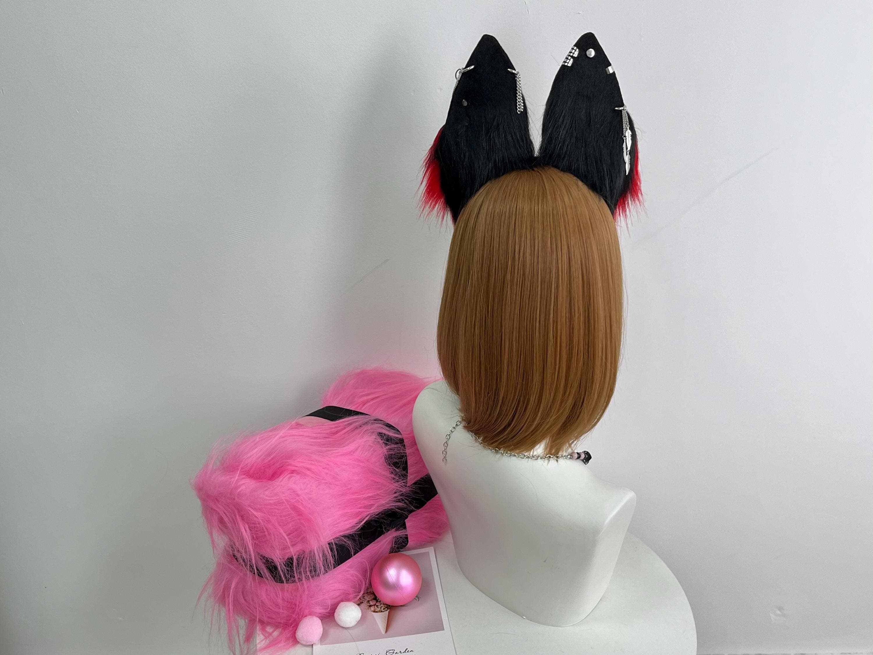 Full back view black wolf ears headband showing solid jet raven black outer rear panels with tiny hints of red fur peeking from behind. Clean matte backside construction with neat stitched seams and the flexible headband arc curving along the top of the head. Demonstrates how the ears look from behind during stage performance walking shots runway poses and convention candid photography. Ideal reference for stealth mount construction quality and real handmade craftsmanship backside.