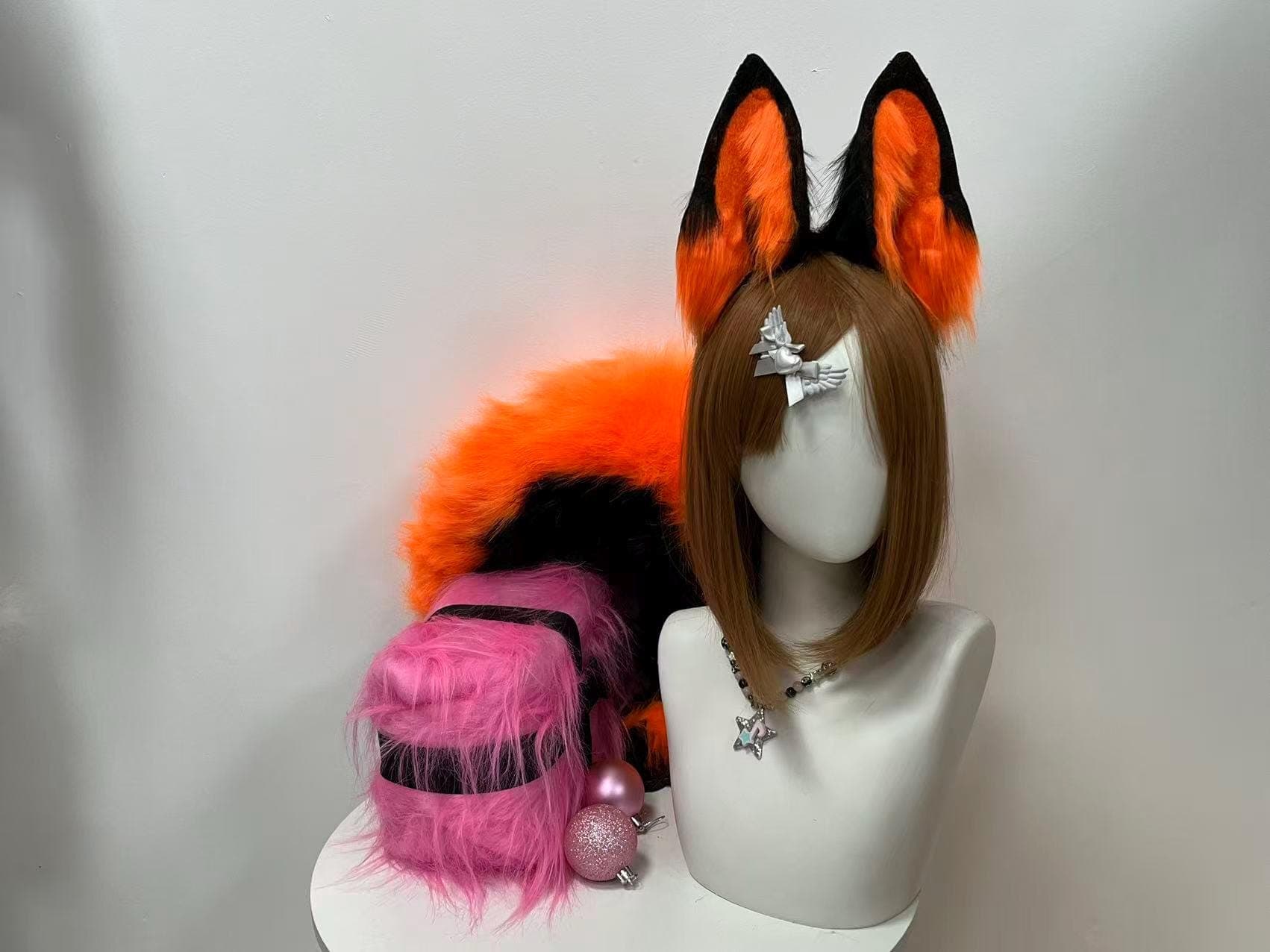 Vibrant orange black fox ears and tail set shown front view with matching poseable fluffy tail visible behind mannequin, soft faux fur construction ideal for furry fursuit partial build kemonomimi anime roleplay Halloween costume. Realistic fox ear shape with black outer edge and orange inner plush creates striking high contrast cosplay look for conventions rave parties festivals photoshoots streaming content. Slim comfy headband sits light all day. Gift idea for anime fans her him.