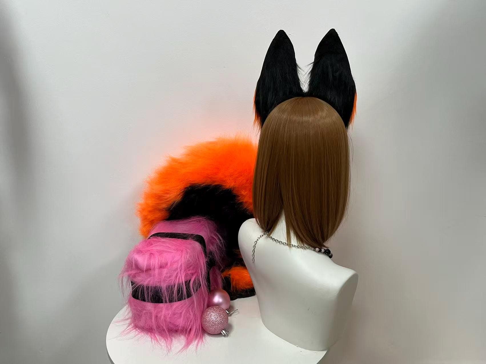 Back view of orange and black fox ears headband showing solid black outer rear of ear construction behind the hairline revealing how poseable plush ears sit naturally on head for kitsune cosplay anime kemonomimi character costume. Realistic fox ear shape with black back side and orange front inner plush faux fur perfect for Halloween furry fandom con photoshoot rave festival outfit. Slim headband disappears into hair. Handmade fox animal ear accessory gift for cosplayer anime lover.