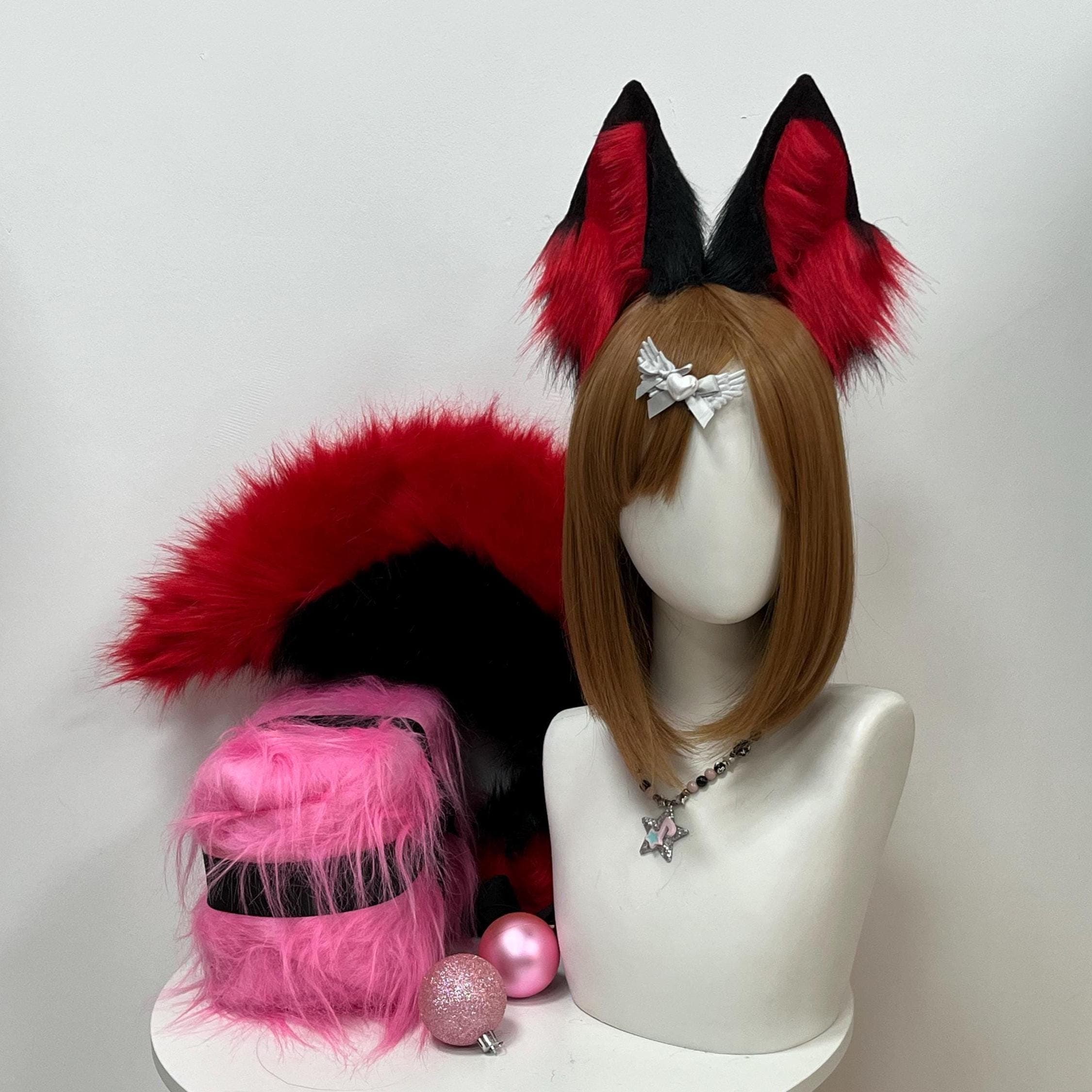 Black and blood red faux fur fox ears headband plus matching long bushy fox tail set front view displayed together as a complete cosplay kit. Tall pointed fox ears with jet black outer shell and vivid scarlet red inner fur shown beside a fluffy two tone tail. Ready for anime convention wear Halloween costumes furry meetups kemonomimi fantasy roleplay themed fantasy parties kitsune looks and fox therian kin expression in one bold dual color ear and tail statement combo for cosplayers.