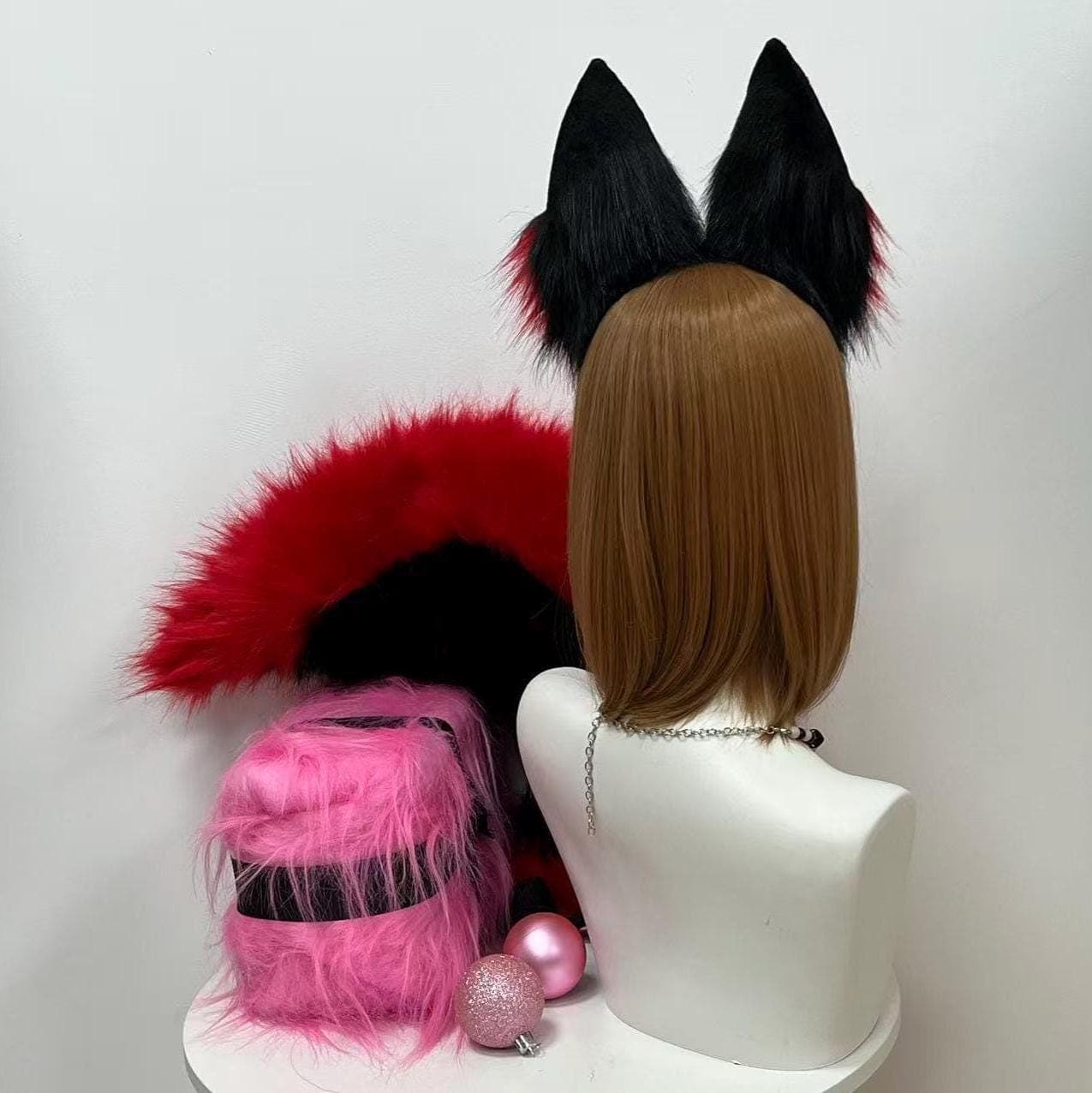Rear back view of black fox ears and tail set showing the solid jet black outer rear panels of the ears with the slim headband arc curving along the head plus the underside of the bushy tail visible to show how dark the underbelly fur runs before transitioning to the bold red topside. Shows unseen construction quality seams stitching and clean matte finish of the backside ideal reference for cosplayers concerned with hidden mounting hardware and outfit integration angles.