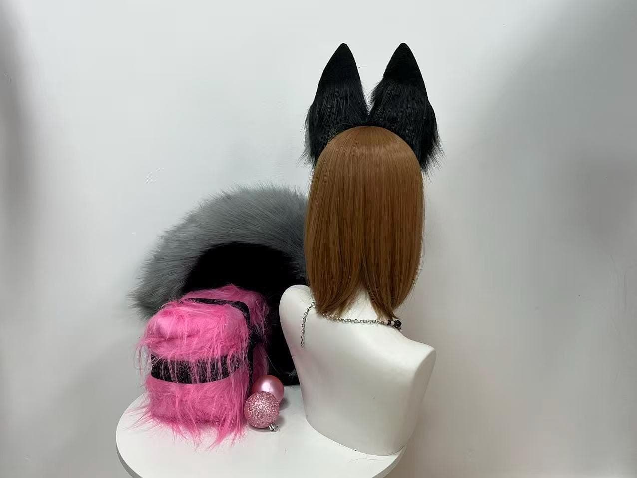 Back view of the faux fur fox ear headband showing how the grey black upright ears sit from behind with neat fur coverage and a discreet headband arch that hides easily under long hair. Shows the smoky poseable tail draped along the side, perfect reference for pop culture cons cosplayers, rave EDM festival outfits, werewolf costume builds, yokai spirit characters, and dark academia aesthetic wear. Hidden wire ear base lets you pose each ear forward, back, or tilted for maximum cute factor.
