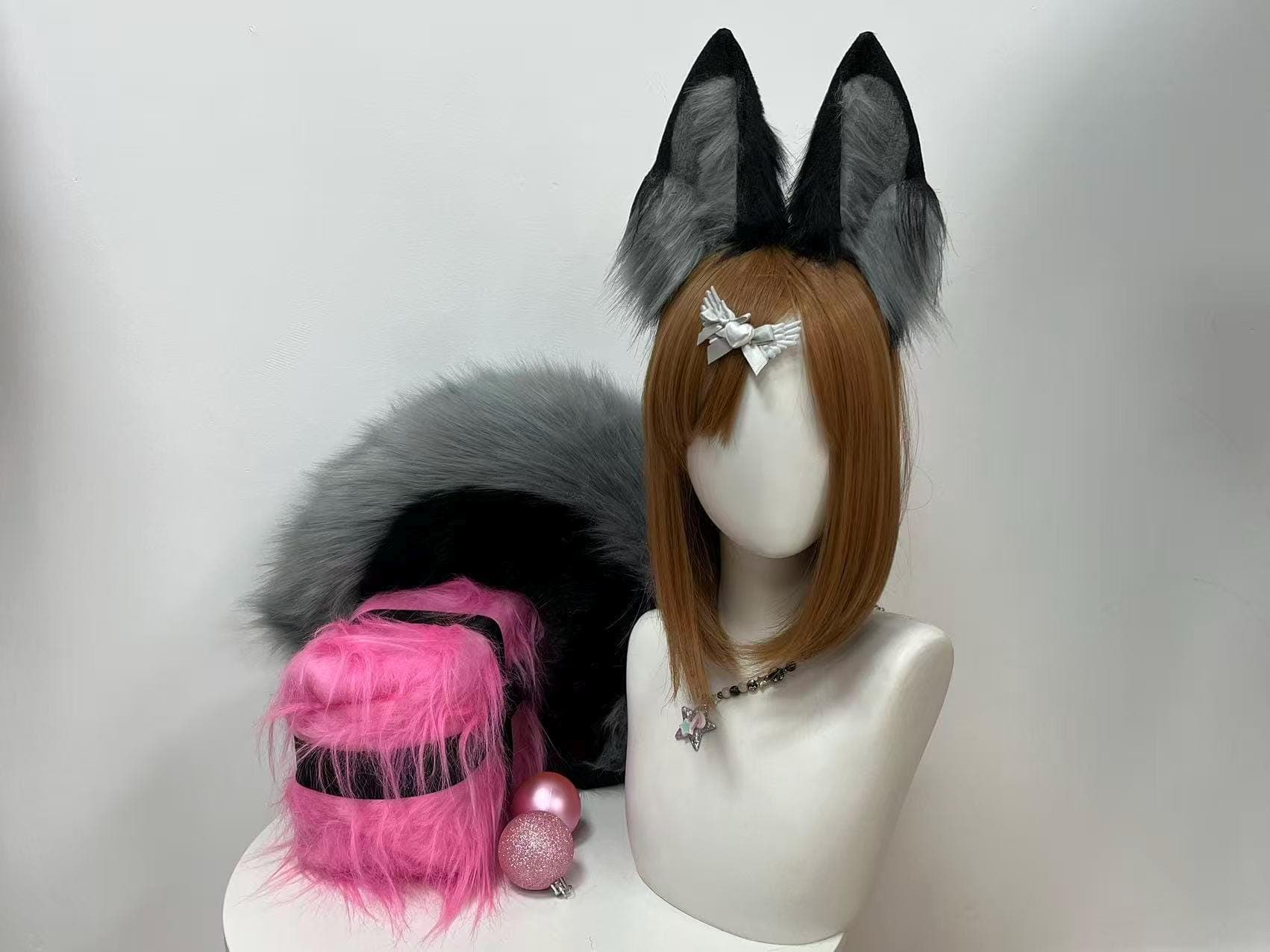 Straight on front view of the wearable fox ear headband and matching faux fur tail in stormy grey and midnight black, showing how the ears frame the face symmetrically and perch high like an alert animal spotting prey. A must have for cosplayers building a midnight fox, arctic wolf hybrid, or ghost kitsune original character. Fantastic for birthday gifts, bachelorette parties, drag looks, theater productions, convention icebreakers, and dramatic costume photography sessions.