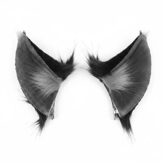 Pair of gray and black clip on wolf ears showing alligator crocodile hair clip attachment at base. Tall pointed faux fur wolf ear hair clips with grey inner fur tufts and black outer fur with wispy fur fringes. Product detail photo showing both ears as matching pair on white background. Clip on wolf ears cosplay accessory with secure metal alligator clip attachment for easy wear. Wolf costume ears for halloween anime con
