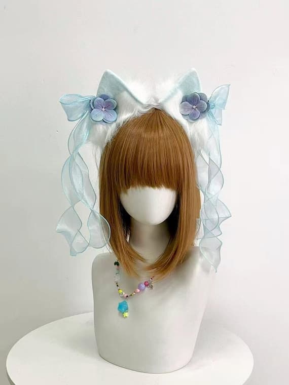 White fluffy faux fur cat ears headband with blue organza ribbon bows and purple hydrangea flowers, perfect for fairy lolita fashion, kawaii neko cosplay, anime conventions, harajuku jfashion, tea party events. Soft plush ears on slim metal headband with decorative ribbons and flowers. Ideal for fairy kei style, lolita coords, sweet lolita outfits, maid cafe costumes, magical girl cosplay, cute gifts for kawaii fashion lovers and cosplayers who appreciate handmade quality costume accessories and