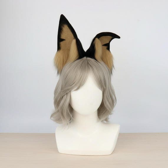 Side angle view of black and tan Doberman dog ear headband on mannequin head with grey-brown wig. Shows pointed ear profile and fluffy tan fur tuft detail. Plush faux fur Doberman Pinscher ear cosplay headband. Realistic dog ears side view showing ear shape and fur texture.