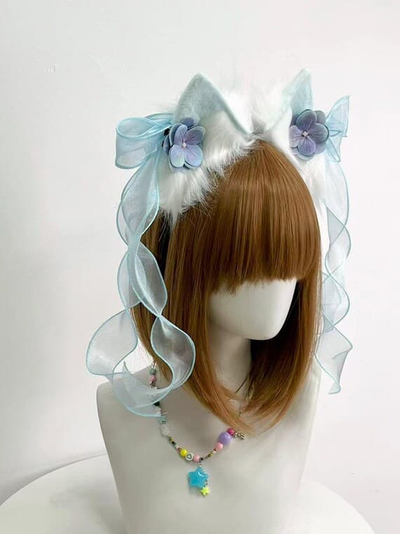 White cat ears headband with blue ribbons and purple flowers styled for fairy lolita showing how bows cascade gracefully and ears sit naturally for neko kawaii look. Perfect for anime conventions, cosplay photoshoots, lolita tea parties, harajuku fashion, jfashion, fairy kei, sweet lolita, maid outfits, streaming props, costume parties. Comfortable all-day wear for conventions, meetups, special events without headaches or slipping during long hours of cosplay and photography sessions